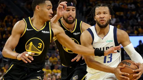 Jalen Brunson of the Dallas Mavericks is defended by Jordan Poole and Klay Thompson of the Golden State Warriors