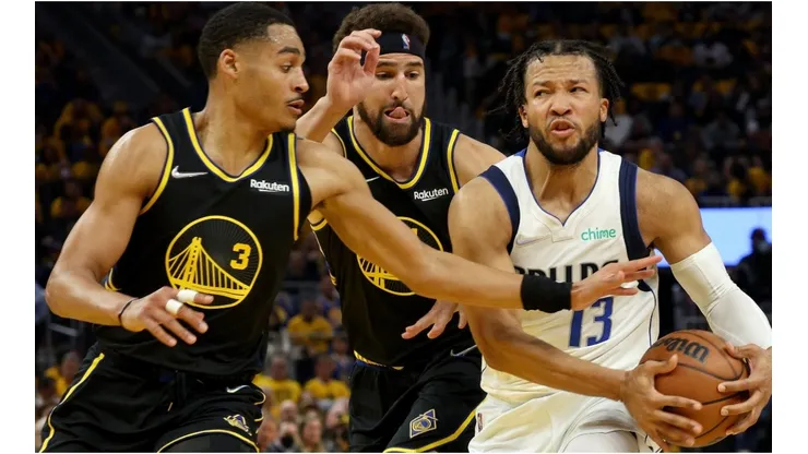 Jalen Brunson of the Dallas Mavericks is defended by Jordan Poole and Klay Thompson of the Golden State Warriors