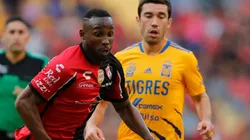 Julian Quiñones of Atlas fights for the ball with Juan Vigon of Tigres UANL