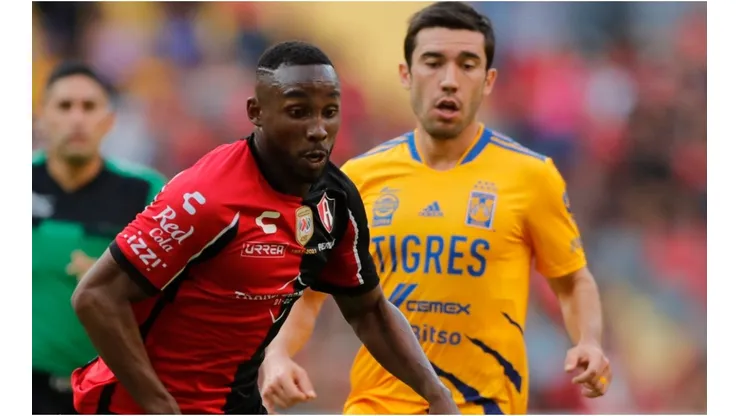 Julian Quiñones of Atlas fights for the ball with Juan Vigon of Tigres UANL