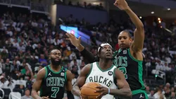 Jrue Holiday of the Milwaukee Bucks is defended by Al Horford and Jaylen Brown of the Boston Celtics