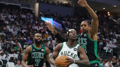 Jrue Holiday of the Milwaukee Bucks is defended by Al Horford and Jaylen Brown of the Boston Celtics