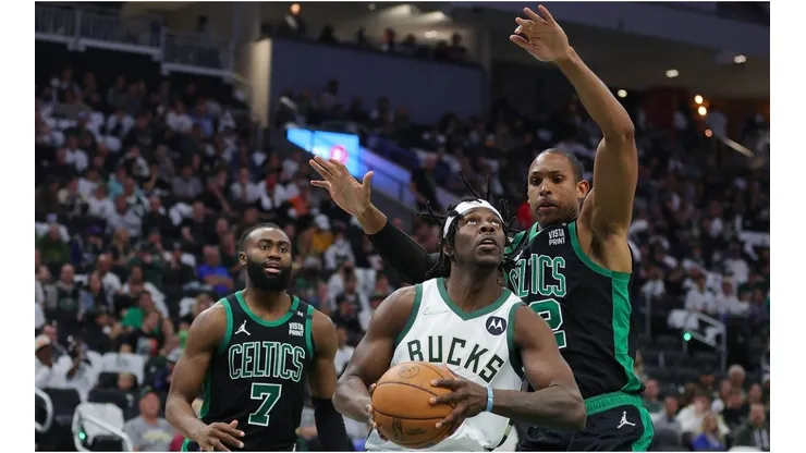 Jrue Holiday of the Milwaukee Bucks is defended by Al Horford and Jaylen Brown of the Boston Celtics