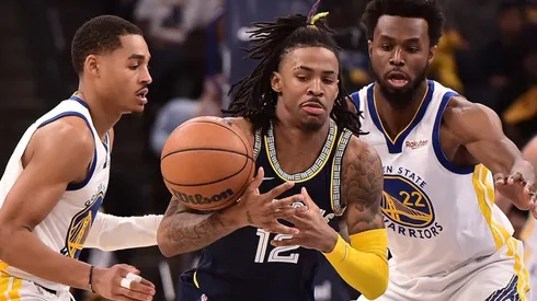 Ja Morant of the Memphis Grizzlies handles the ball against Andrew Wiggins and Jordan Poole of the Golden State Warriors