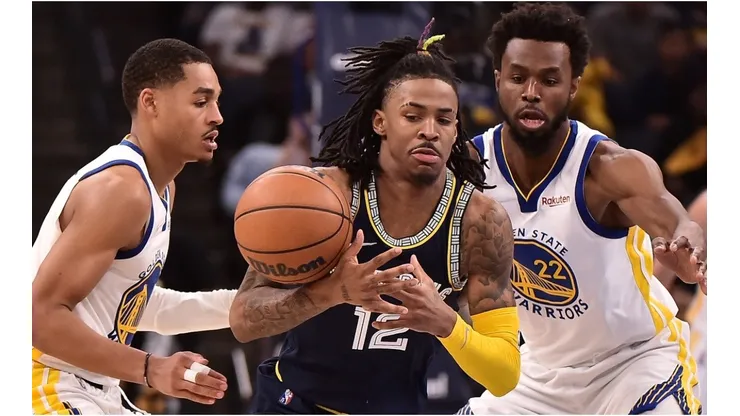 Ja Morant of the Memphis Grizzlies handles the ball against Andrew Wiggins and Jordan Poole of the Golden State Warriors