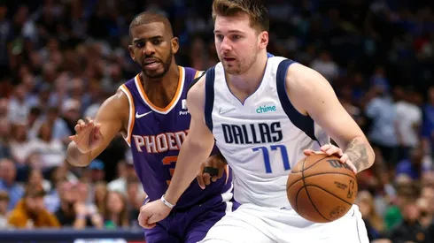 Luka Doncic of the Dallas Mavericks handles the ball as Chris Paul of the Phoenix Suns defends