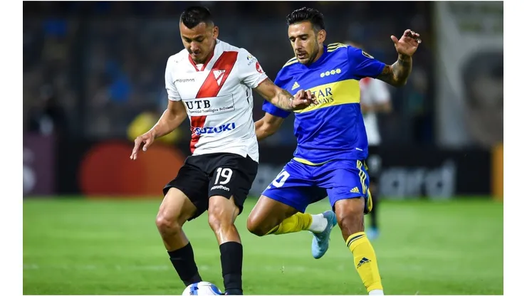 Jorge Flores of Always Ready fights for the ball with Eduardo Salvio of Boca Juniors