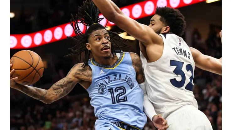 Ja Morant of the Memphis Grizzlies goes up for a shot while Karl-Anthony Towns of the Minnesota Timberwolves defends