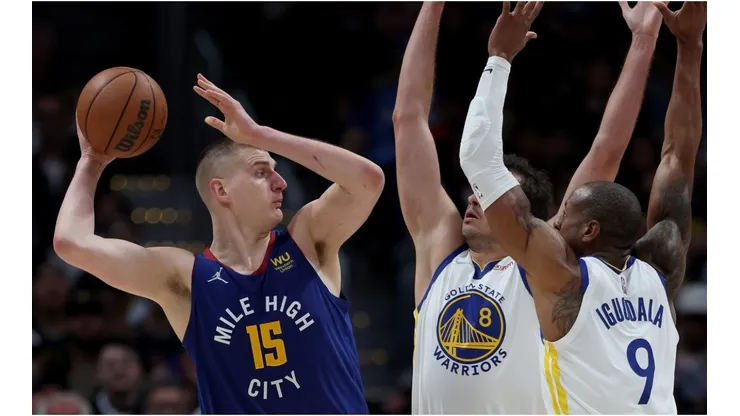 Nikola Jokic of the Denver Nuggets is guarded by Nemanja Bjelica and Andre Iguodala of the Golden State Warriors