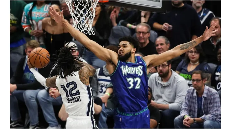 Ja Morant of the Memphis Grizzlies goes up for a shot past Karl-Anthony Towns of the Minnesota Timberwolves