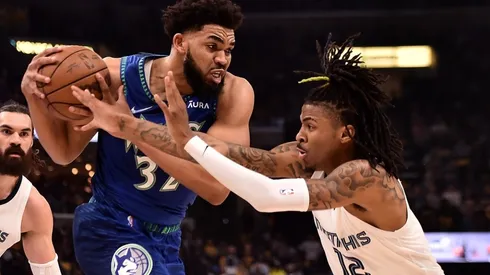 Karl-Anthony Towns of the Minnesota Timberwolves handles the ball against Ja Morant of the Memphis Grizzlies