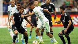 Paulo Dybala controls the ball surrounded by Mexican players in a friendly match