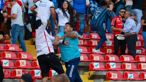 Fans of Atlas and Queretaro fight in the stands during the 9th round match between Queretaro and Atlas