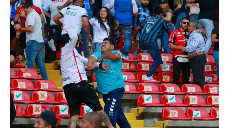 Fans of Atlas and Queretaro fight in the stands during the 9th round match between Queretaro and Atlas
