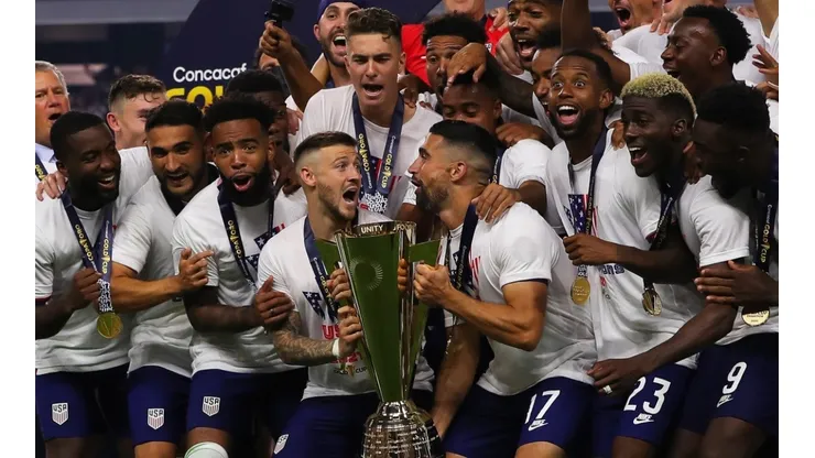 Paul Arriola #7 of United States and Sebastian Lletget #17 lifts the trophy to celebrate with his teammates after winning the CONCACAF Gold Cup 2021
