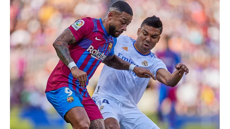 Memphis Depay of FC Barcelona and Casemiro of Real Madrid CF battle for the ball.