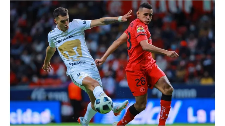 Oscar Venegas of Toluca struggles for the ball against Juan Dinenno of Pumas during the repechage match between Toluca and Pumas