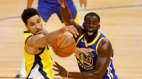 Malcolm Brogdon of Pacers (left) fights for ball possession against Draymond Green of Warriors