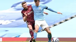 Stuart Dallas of Leeds United (left) fights for ball possession against John Stones of Manchester City