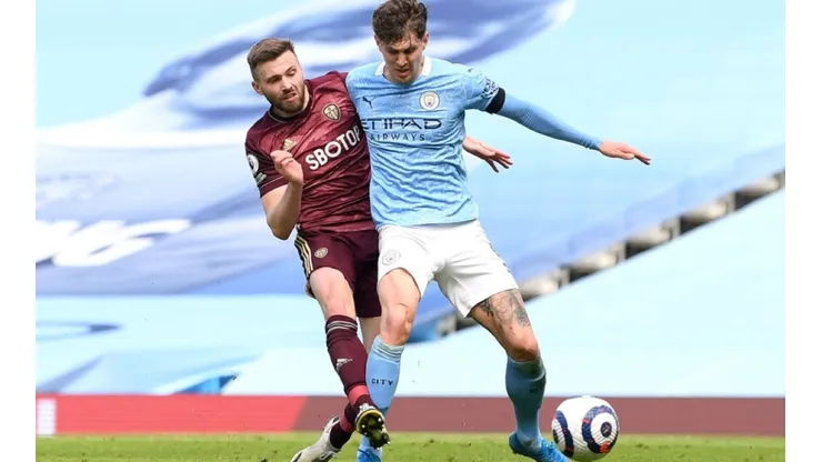 Stuart Dallas of Leeds United (left) fights for ball possession against John Stones of Manchester City
