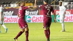 Saprissa's players celebrate a goal by touching elbows