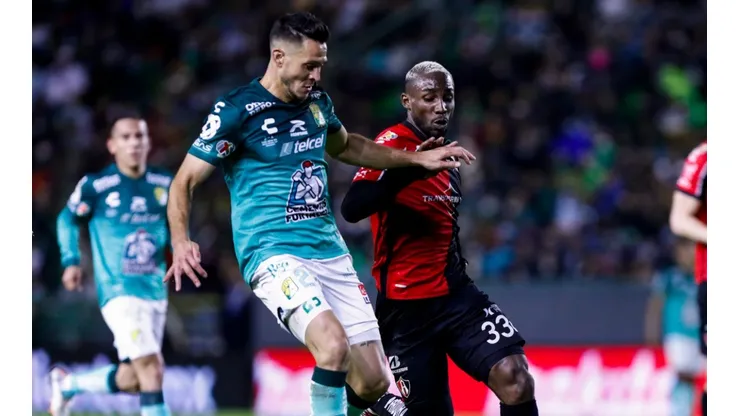 Julián Quiñones of Atlas fights for the ball with Ramiro González of Leon