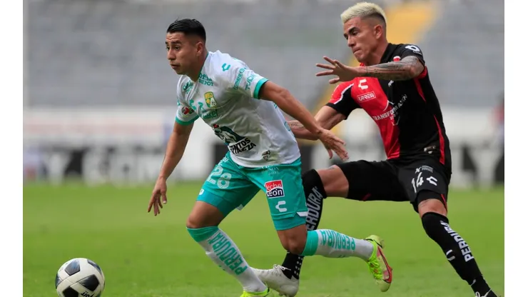 Luis Reyes #14 of Atlas fights for the ball with José Ramírez #28 of Leon.