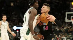Jrue Holiday of Bucks (left) tries to block pass Tyler Herro of Heat