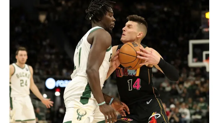 Jrue Holiday of Bucks (left) tries to block pass Tyler Herro of Heat