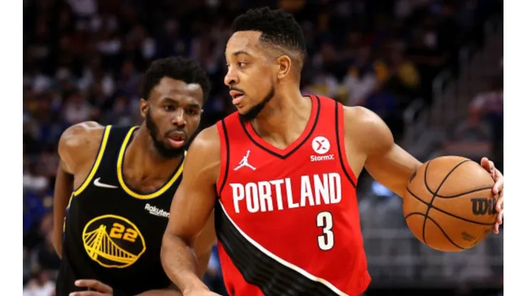 Andrew Wiggins of Warriors (left) tries to stop CJ McCollum of Portland Trail Blazers
