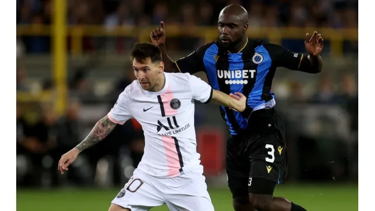 Lionel Messi of PSG (left) tries to hold ball possession against Eder Balanta of Club Brugge