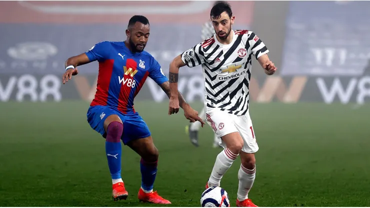 Jordan Ayew of Crystal Palace (left) fights for ball control against Bruno Fernandes of Manchester United