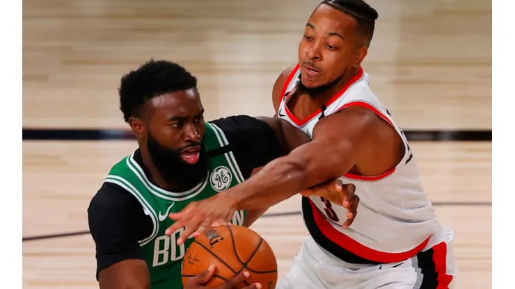 Jaylen Brown of Celtics (left) tries to avoid CJ McCollum of Blazers