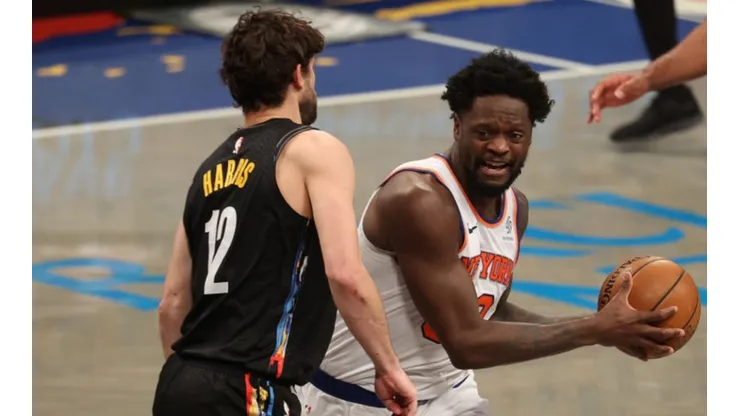 Joe Harris of Nets (left) tries to block Julius Randle of Knicks by Al Bello