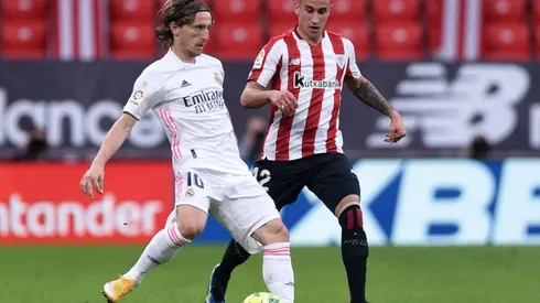 Luka Modric of Real Madrid (left) tries to pass the ball infront of defender Alex Berenguer of Athletic Bilbao