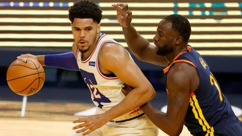 Tobias Harris of 76ers (left) tries to avoid defender Draymond Green of Warriors