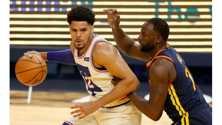 Tobias Harris of 76ers (left) tries to avoid defender Draymond Green of Warriors