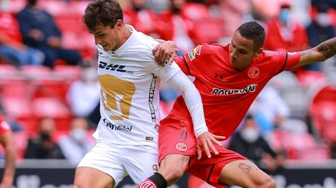 Diego Chávez of Toluca vies for the ball against Juan Dinenno of Pumas