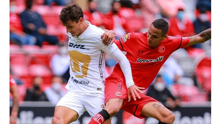 Diego Chávez of Toluca vies for the ball against Juan Dinenno of Pumas