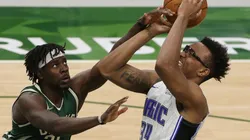 Jrue Holiday of Milwaukee (left) trying to block a shot of Wendell Carter Jr of Orlando