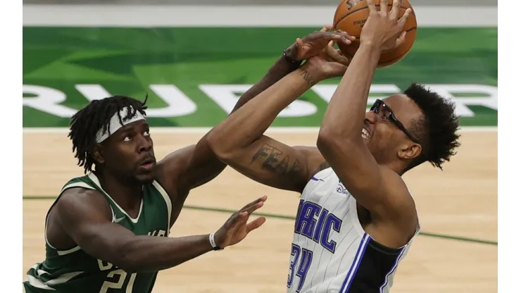Jrue Holiday of Milwaukee (left) trying to block a shot of Wendell Carter Jr of Orlando