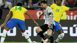 Lionel Messi of Argentina competes for the ball with Eder Militão (L) and Vinicius Junior (R) of Brazil