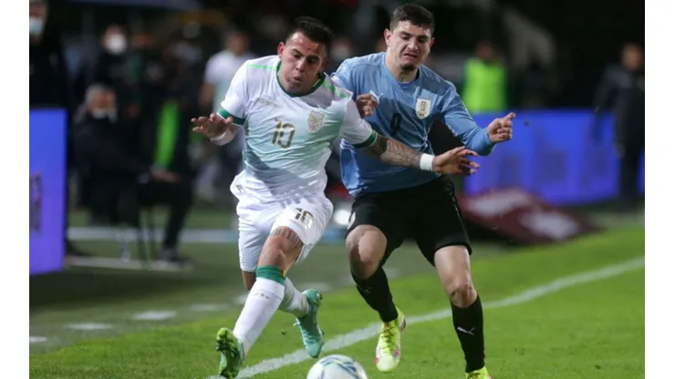 Henry Vaca of Bolivia (left) tries to avoid defender Agustín Alvarez Martínez of Uruguay during a game for the Qualifiers on September 5