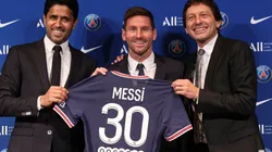 Lionel Messi poses with his jersey next to President Nasser Al Khelaifi and Leonardo