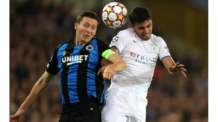 Hans Vanaken of Club Brugge (left) tries to defend a header against Rodrigo of Manchester City
