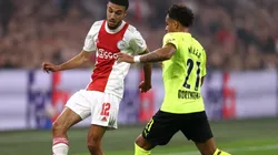 Noussair Mazraoui of Ajax (left) tries to pass the ball infront to avoid Donyell Malen of Borussia