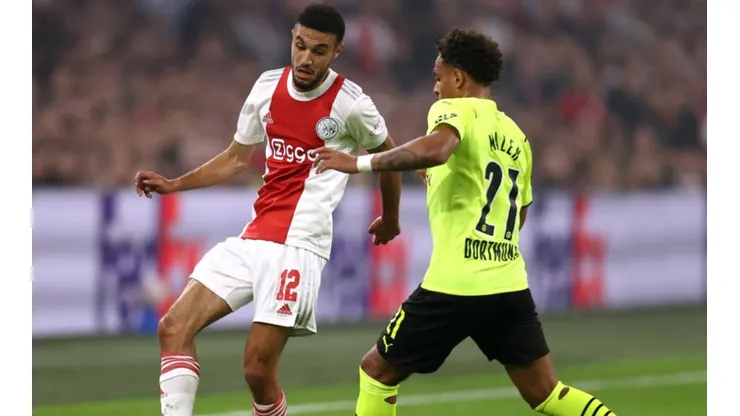 Noussair Mazraoui of Ajax (left) tries to pass the ball infront to avoid Donyell Malen of Borussia