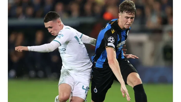 Phil Foden of Manchester City (left) fights for ball possession against Jack Hendry of Club Brugge