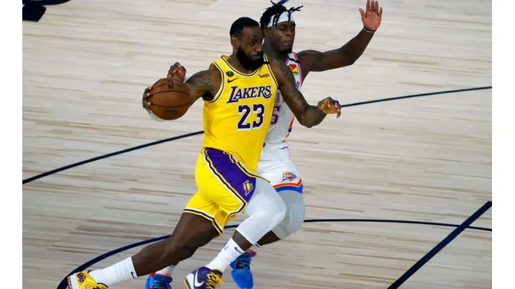 LeBron James of the Lakers (left) tries to pass Luguentz Dort of the Thunder