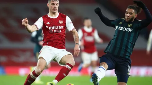 Granit Xhaka of Arsenal (left) fights for ball possession against Tyler Roberts of Leeds United